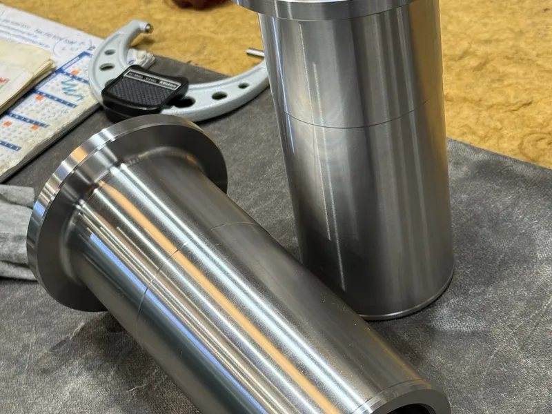 Machined steel components being checked with precision measuring tools